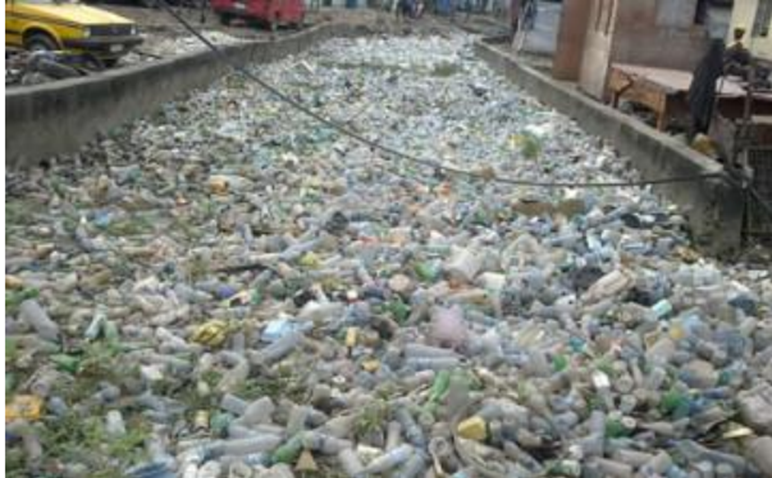 Alt = Plastic bottles blocking a drain in Lagos